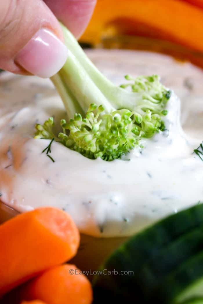dipping broccoli into low carb dill dip