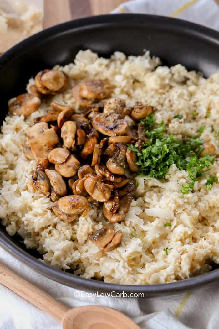 Cauliflower Mushroom Risotto in a skillet topped with mushrooms and parsley