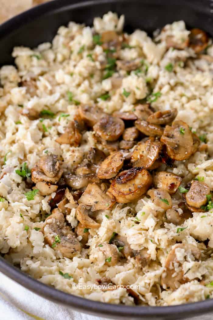 closeup of Cauliflower Mushroom Risotto in a skillet topped with mushrooms and parsley