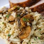 Cauliflower Mushroom Risotto in a skillet with mushrooms and parsley served on a plate with meat