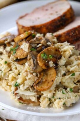 Cauliflower Mushroom Risotto in a skillet with mushrooms and parsley served on a plate with meat