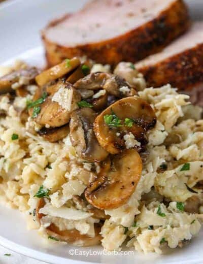 Cauliflower Mushroom Risotto in a skillet with mushrooms and parsley served on a plate with meat
