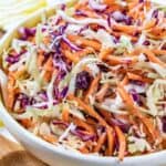 coleslaw in a serving dish with serving utensil on the side