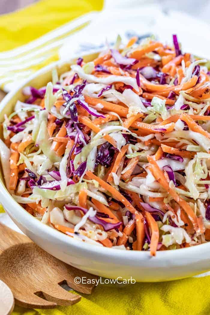 coleslaw in a serving dish with serving utensil on the side