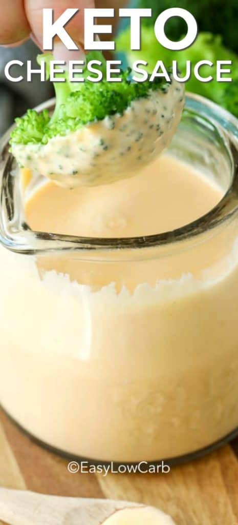 dipping broccoli into Keto Cheese Sauce in a clear glass jar, with text
