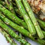 closeup of roasted asparagus on a white plate