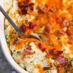 Cauliflower casserole being scooped out with a silver spoon