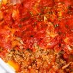 Unstuffed cabbage casserole in white casserole dish with one serving removed