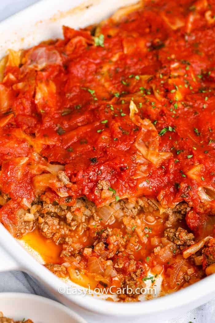 Unstuffed cabbage casserole in white casserole dish with one serving removed