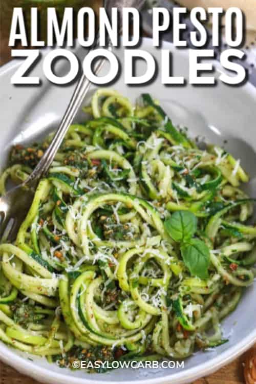 Almond Pesto Zoodles garnished with basil with a title.