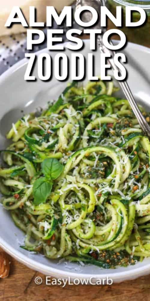 Almond Pesto Zoodles garnished with basil in a white dish with writing