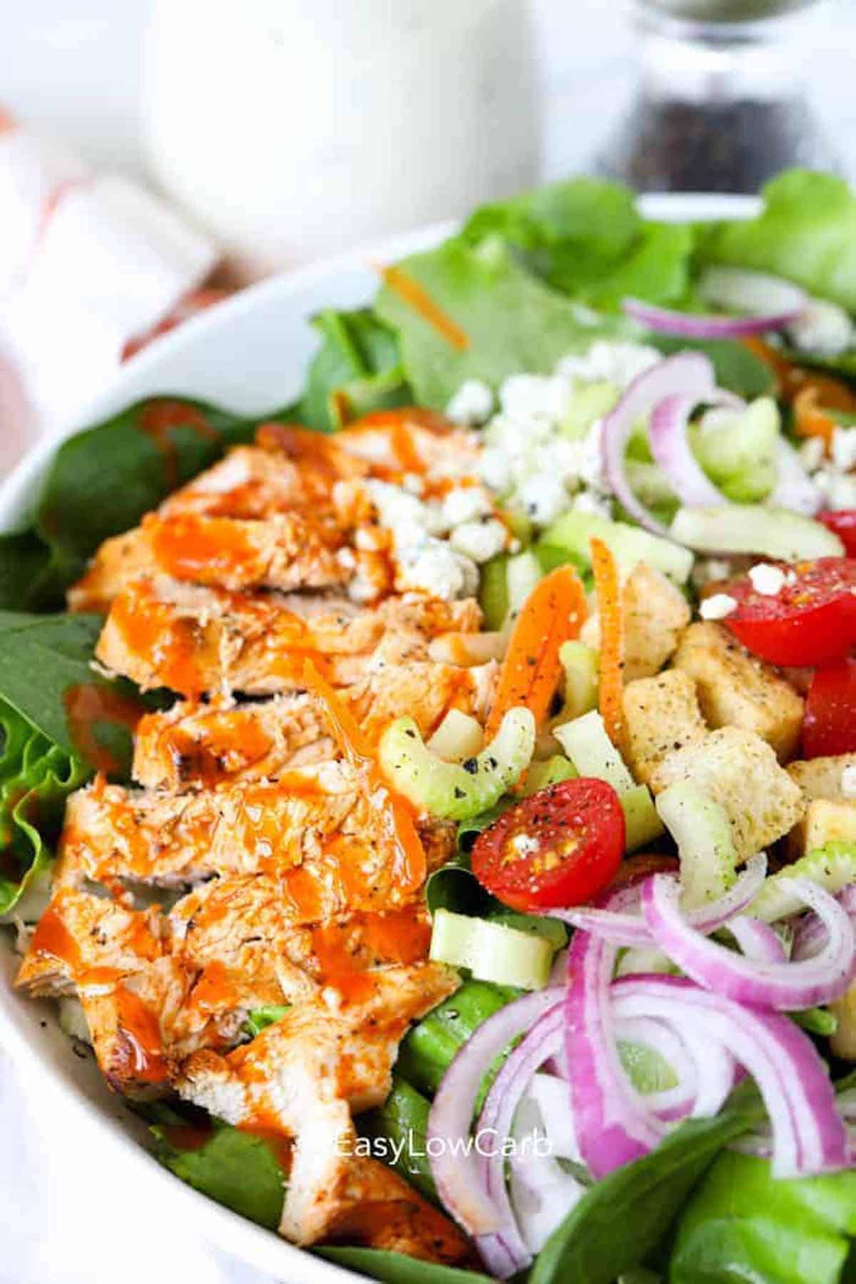 Close up of buffalo chicken on top of a salad