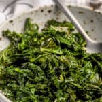 sauteed kale and garlic in a bowl with a spoon.