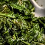 sauteed kale and garlic in a bowl with a silver spoon and a title