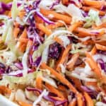 Low carb coleslaw served in a white bowl with a wooden spoon on the side with a title
