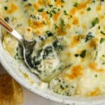 close up of Baked Spinach Artichoke Dip with a spoon