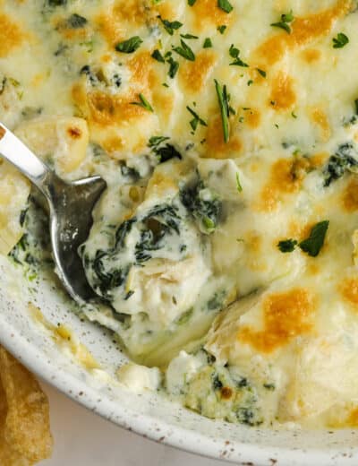 close up of Baked Spinach Artichoke Dip with a spoon