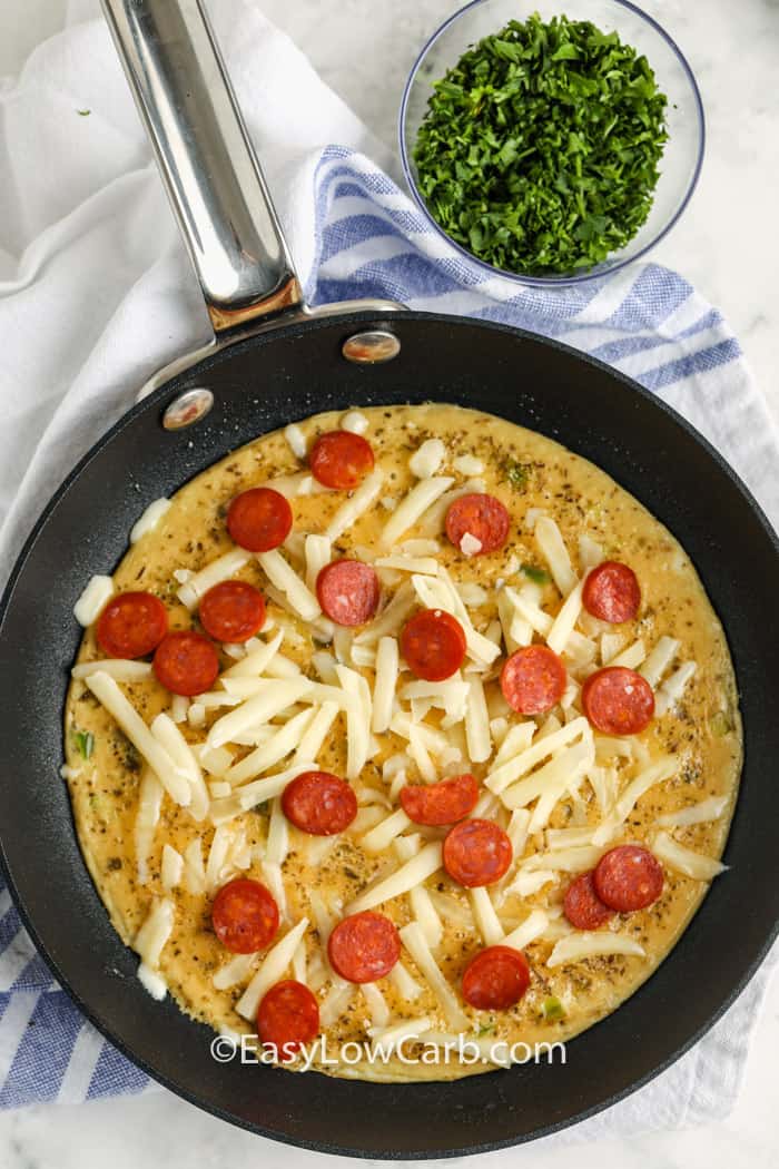 This crustless keto breakfast pizza packs familiar pizza flavor into an easy single-serving breakfast. A tender egg crust is seasoned with oregano, then topped with mozzarella and pepperoni before a quick broil makes everything hot and melty. Serve low-carb tomato sauce alongside for dipping so the egg base stays firm. It is simple, practical, and ready in about 15 minutes. Save this cheesy keto breakfast recipe to make soon. #easylowcarb top view of cooking Keto Breakfast Pizza