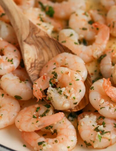 close up of wooden spoon scooping butter garlic shrimp