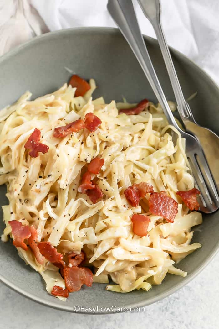 creamed cabbage in a bowl with fork and spoon