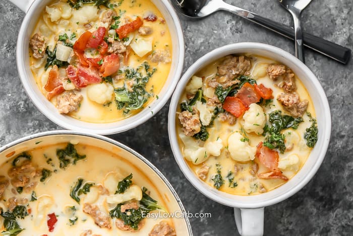 a pot and two bowls of zuppa toscana