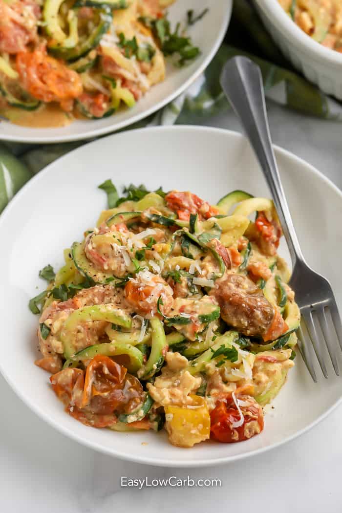 feta zucchini pasta in a white bowl with a fork