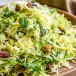 shredded brussel sprout slaw in a bowl with text