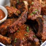 Close up of crock Pot BBQ Ribs on a serving tray with sauce