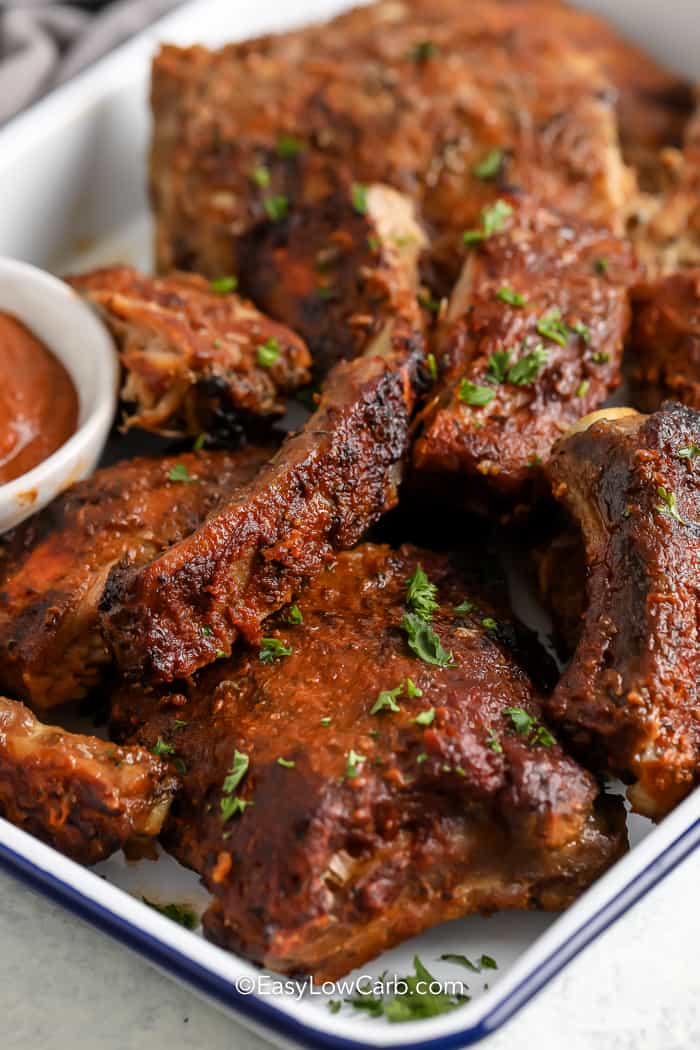 Close up of crock Pot BBQ Ribs on a serving tray with sauce