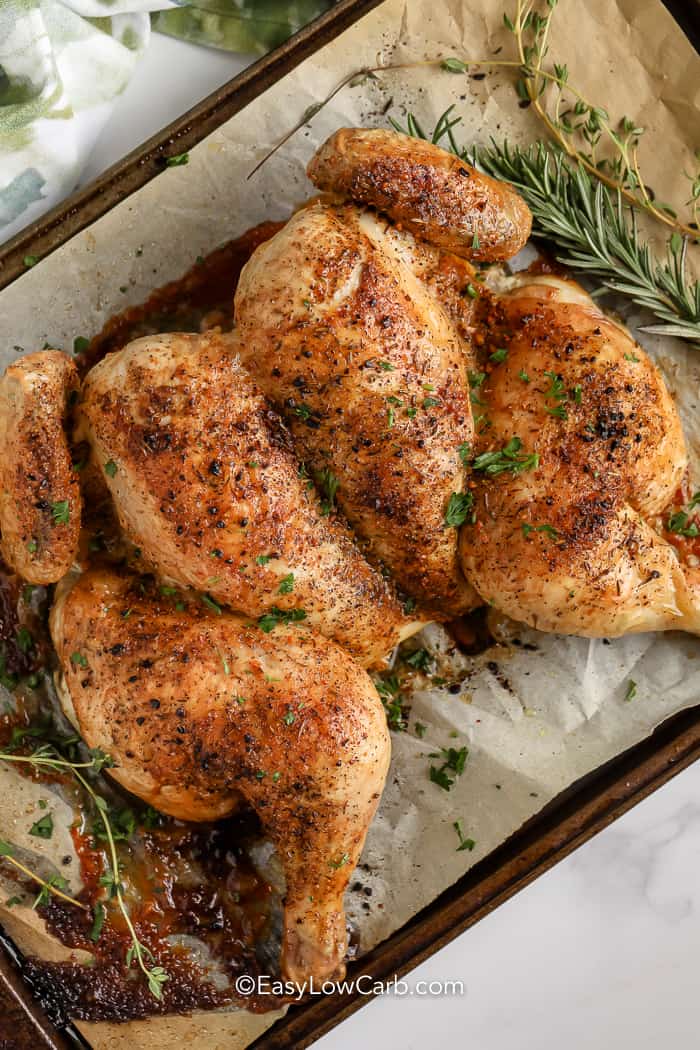 cooked Butterflied Chicken on a pan topped with parsley