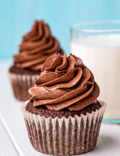 two chocolate cupcakes and a glass of milk