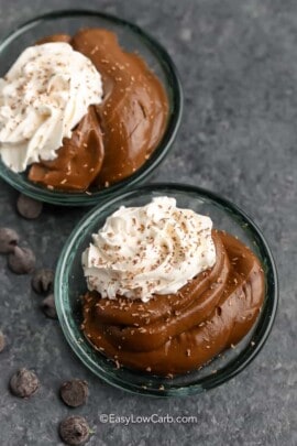 Two dishes of Avocado Chocolate Pudding with whipped cream and chocolate shavings
