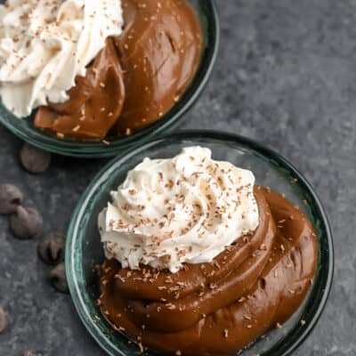 Two dishes of Avocado Chocolate Pudding with whipped cream and chocolate shavings