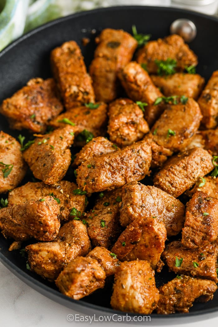 cajun pork bites in a pan with parsley