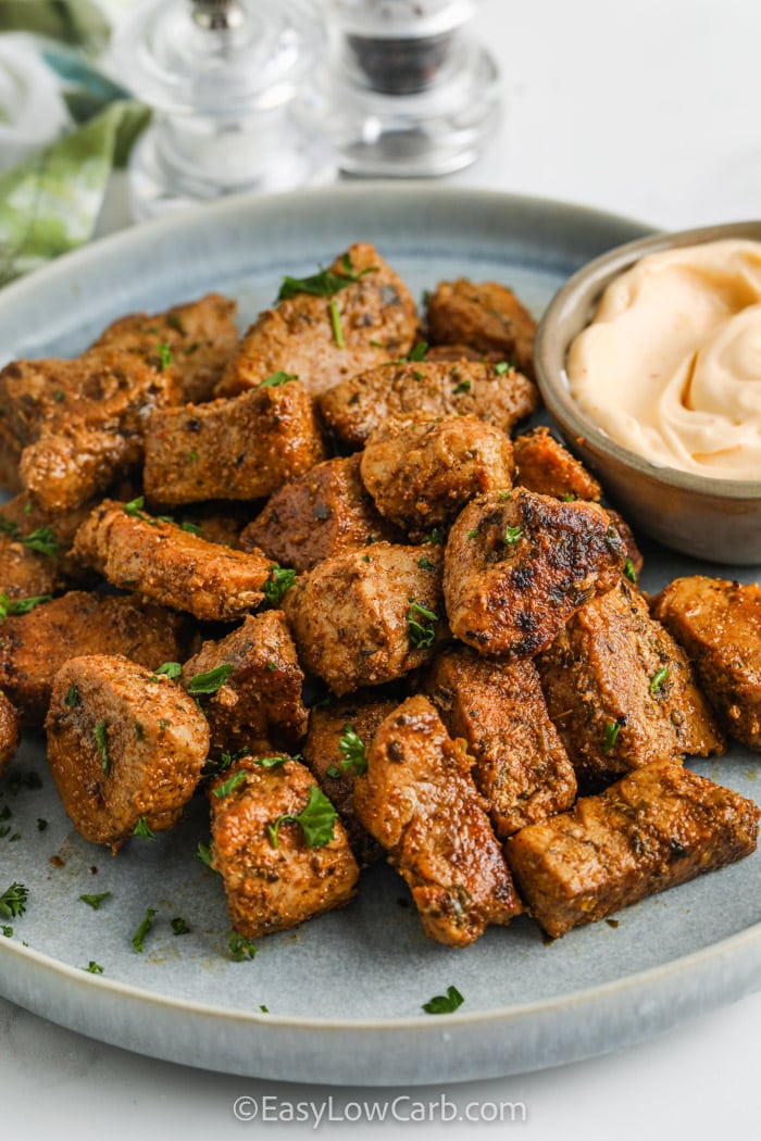 Cajun Pork Bites on a serving plate with dip