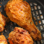 Keto Air Fryer Chicken cooked in an air fryer basket with writing