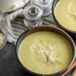 Cauliflower Leek Soup in bowls with parmesan cheese on top