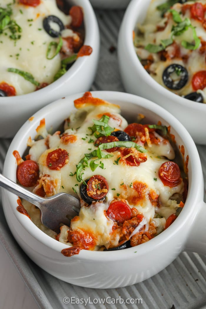 three white bowls filled with low carb Pizza Bowl Recipe, one bowl has a fork in it.