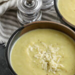 Cauliflower Leek Soup in bowls with parmesan cheese and writing