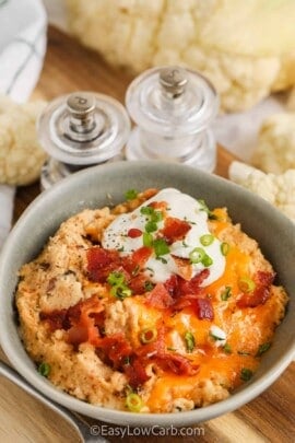 Twice Baked Cauliflower Casserole with bacon, sour cream, and green onions on top