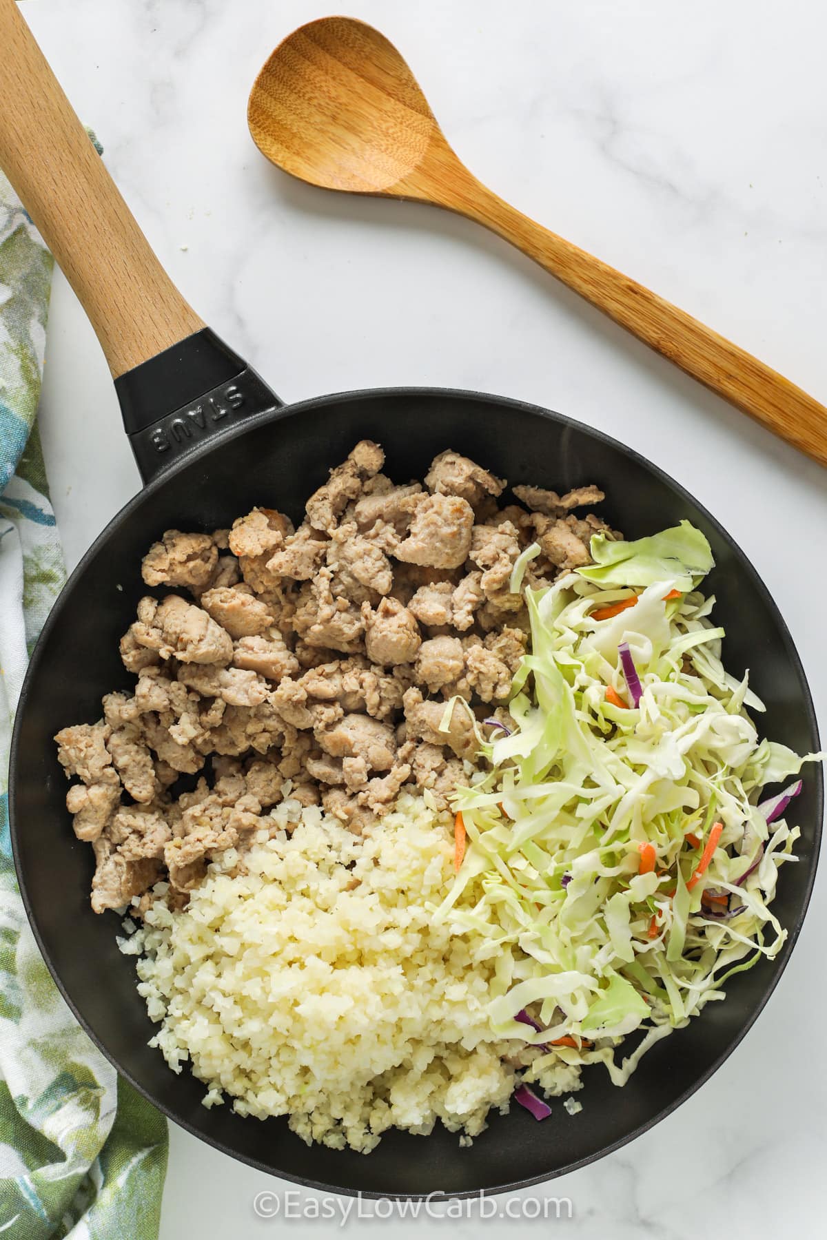 If you want an easy cabbage stir fry that is not complicated, this one-pan method keeps it simple. Start by browning ground beef or chicken with garlic and ginger, then add cauliflower rice to keep it low carb and filling. Cook most of the coleslaw mix until tender, then add the rest briefly so it stays crisp-tender. Season to taste and serve right away for the best texture. #easylowcarb ingredients for Easy Stir Fry Chicken and Vegetables in a skillet before being mixed