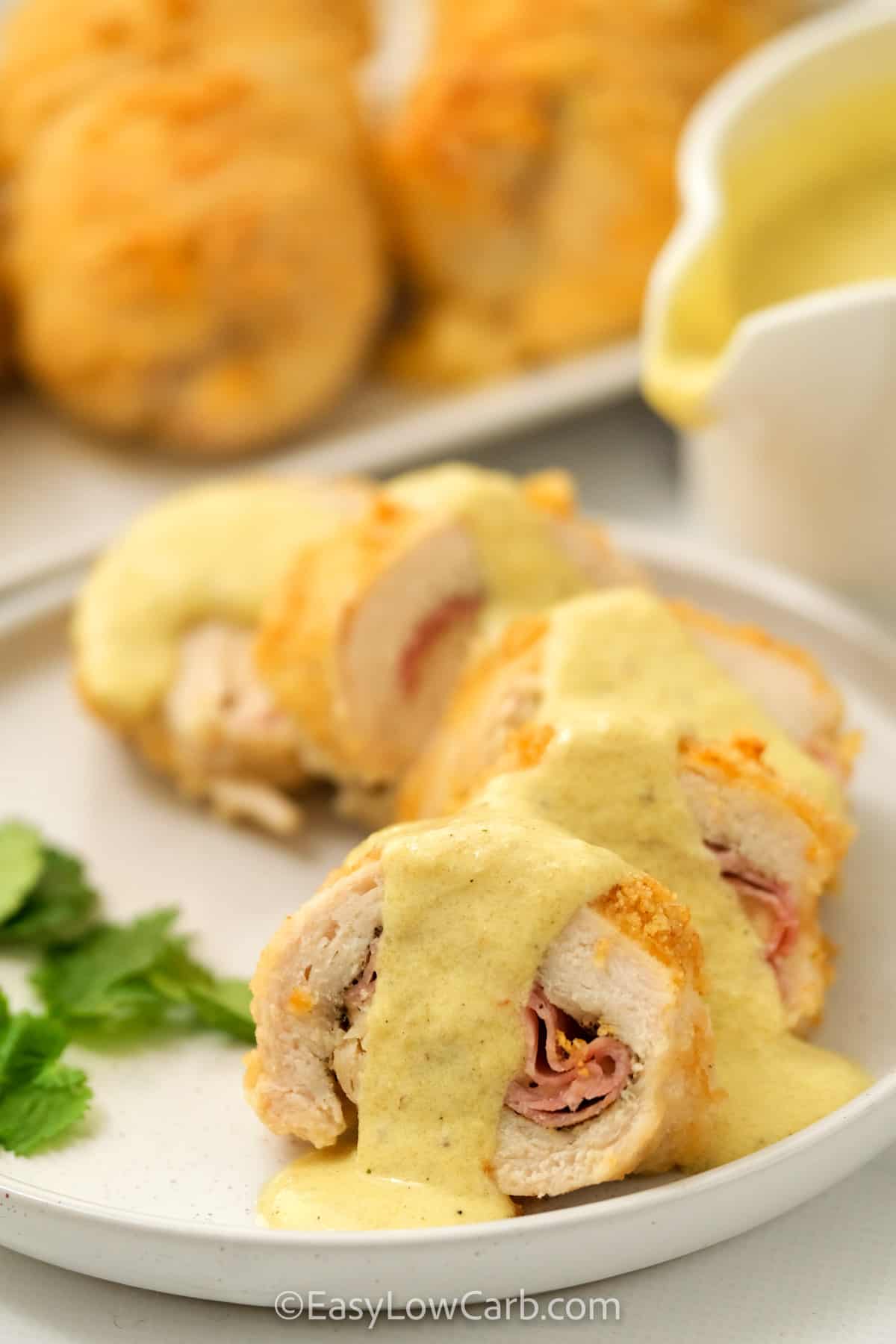 Keto Chicken Cordon Bleu on a plate with sauce on a serving plate