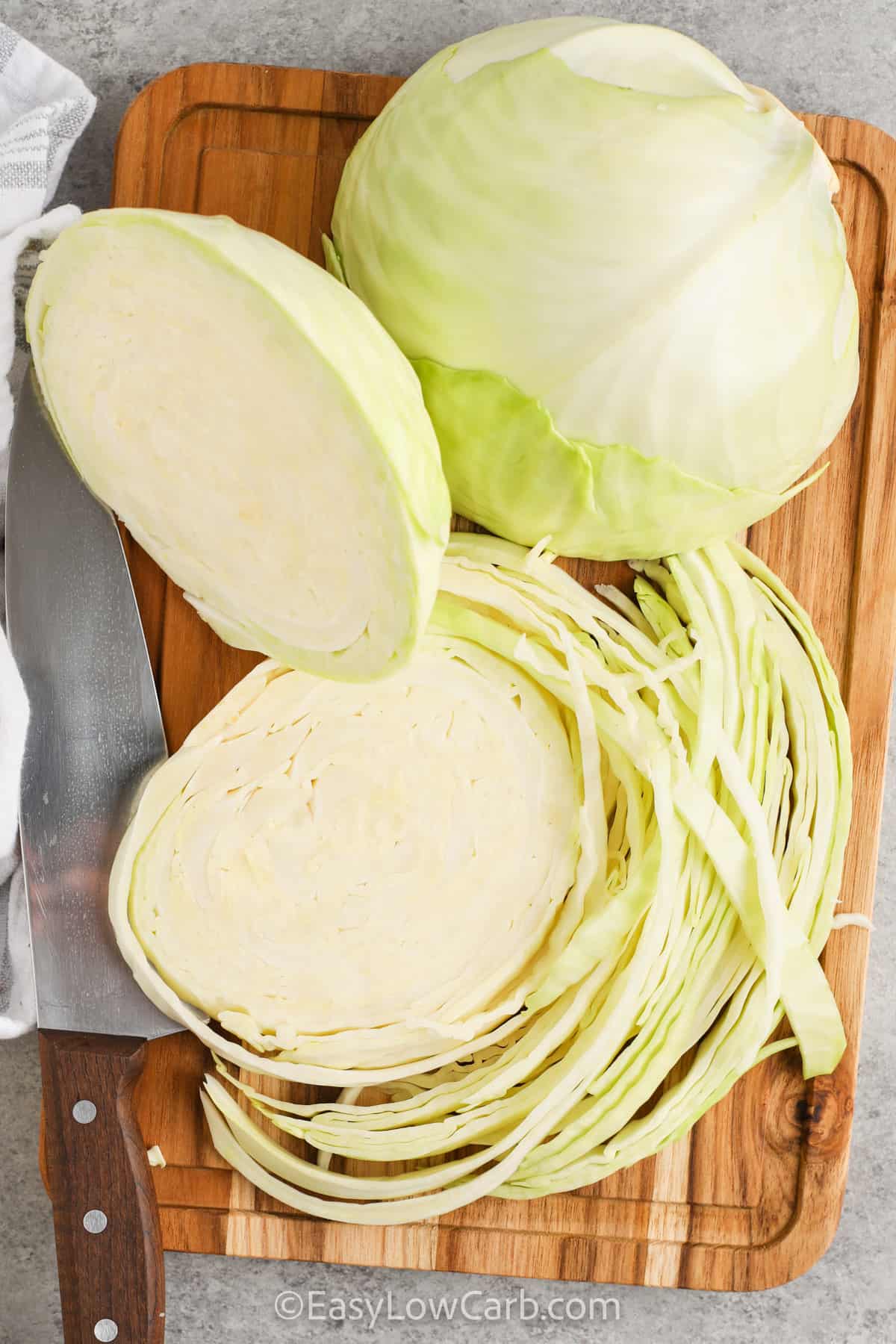 cabbage being cut on a wooden board with a knife