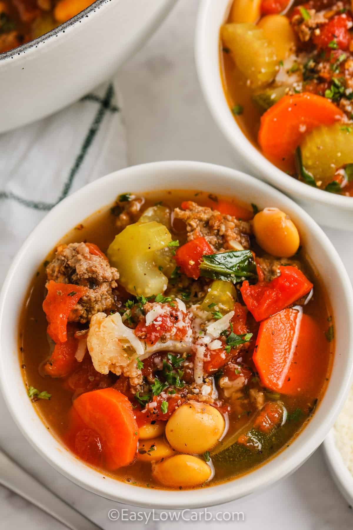 Keto Minestrone Soup in white bowls with cheese on top