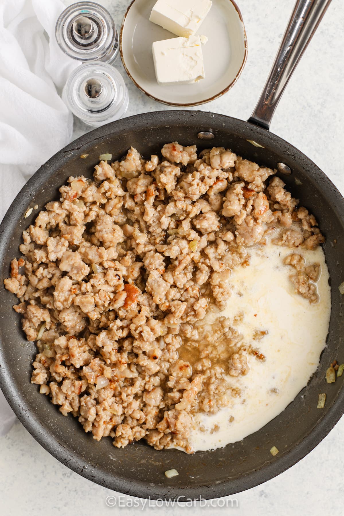 Keto Sausage Gravy ingredients in a pan before being stirred