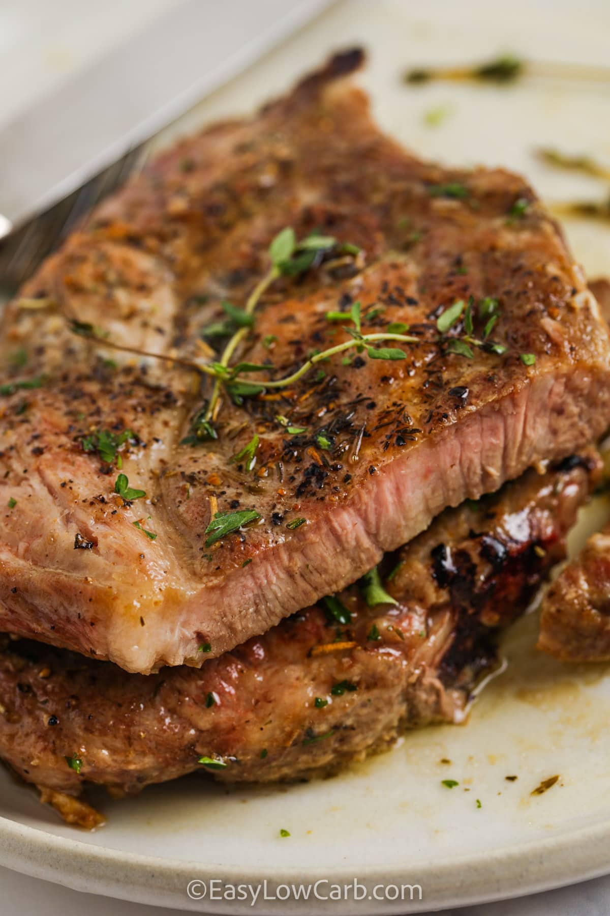 Pan Seared Pork Chops on a plate cut open to see the inside