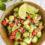 Avocado Salsa in a bowl with lime wedges