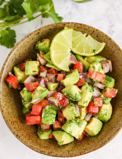 Avocado Salsa in a bowl with lime wedges