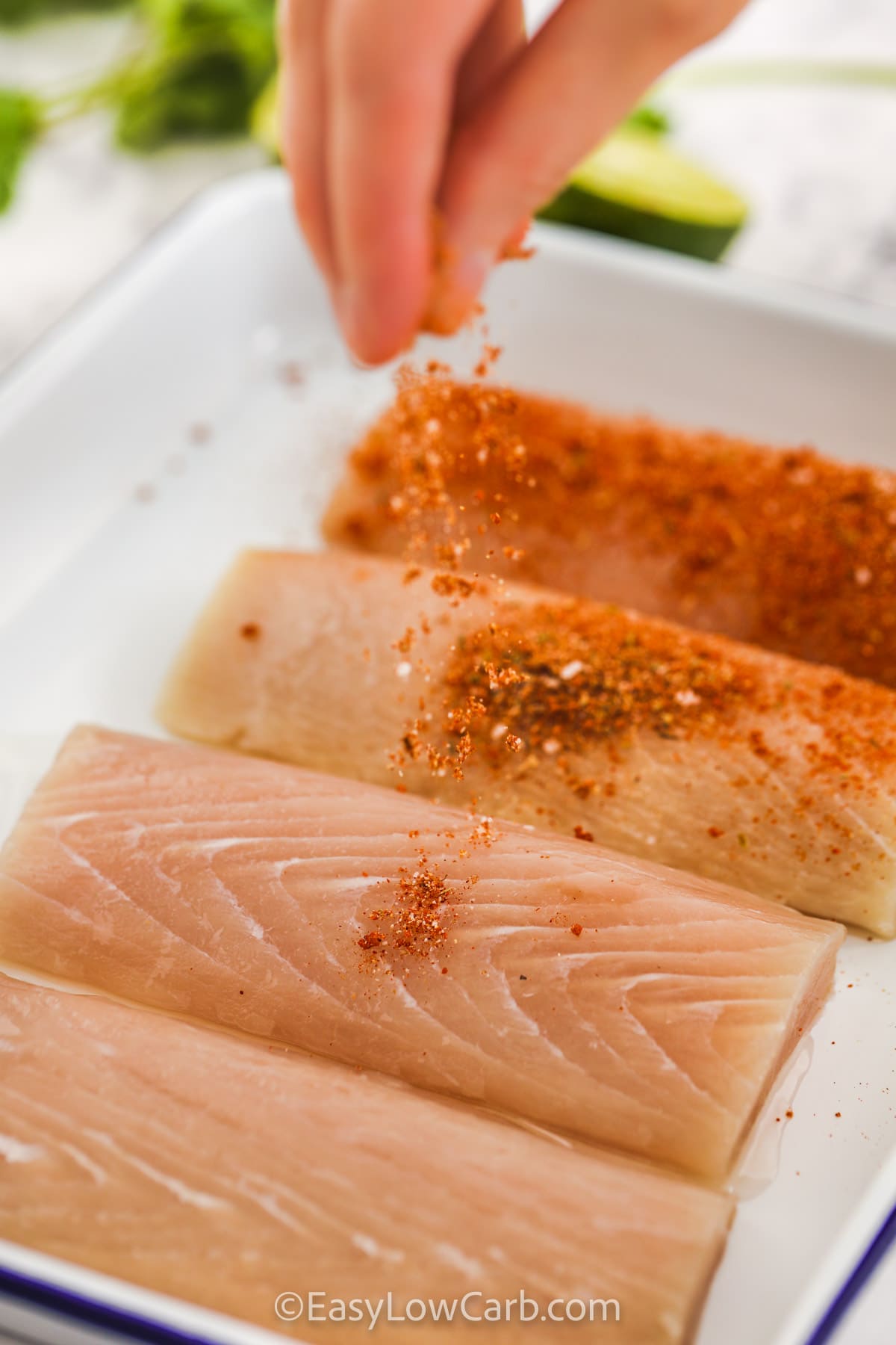 Blackened seasoning being sprinkled on top of Mahi Mahi Fillets