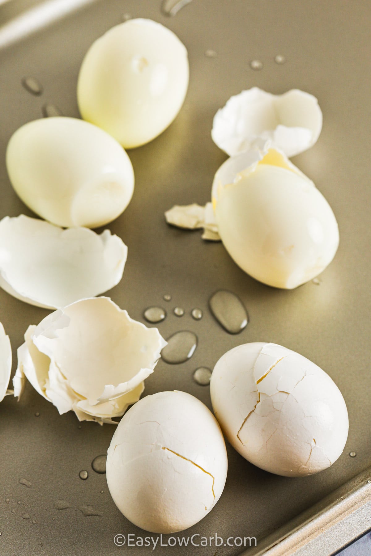 Hard Boiled Eggs being peeled on a baking sheet